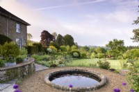 Formal terraced garden with circular pond in May.