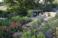 Wide view of the garden with view of fields behind, Chicken coop and pizza oven. Euphorbia ceratocarpa,
Erysimum 'Bowles Mauve',
Foeniculum vulgare ' Purpureum' - Bronze Fennel,
Nepeta 'Dawn to Dusk',
Sweet Pea 'Blue Ripple', 'Hi Scent', and 'Cupani',
Dahlia 'Totally Tangerine', 'Jowey Mirella', 'New Baby', 'Downham Royal', 'Sam
 Hopkins', 'Ambition' and Hydrangea  arborescens 'Annabelle'.