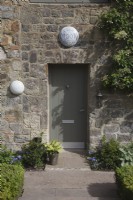 front entrance to the house, Full Moon Barn light on the stone wall and front door.