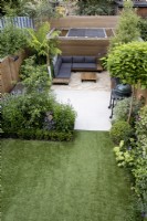 High view of small suburban garden with artificial lawn,  patio and wood pergola