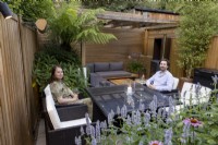 Man and woman sitting around table in small suburban garden