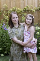 Portrait of mother with young daughter in garden