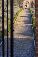 A gateway onto the gravel paths that leads through the wall kitchen garden at Redisham Hall Nurseries.
