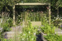 Water rill trough planting of Veronicastrum 'Lavendelterm' and white Hydrangea mixed with grasses under Parrotia persica trees with metal pergola behind - Macmillan Legacy Garden: Gift the Future - RHS Hampton Court Flower Festival 2022