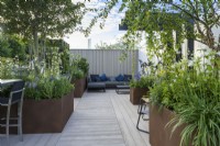Raised Corten steel planters with perennials and trees  on  deck seating area - John King Brain Tumor Foundation Garden, RHS Hampton Court Palace Garden Festival 2022