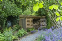 Log store incorporating recycled pallets and a green roof. June.