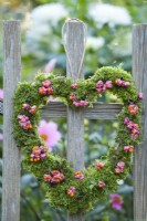 Moss heart wreath decorated with spindle berries.