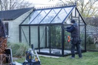 Man placing glass in the greenhouse
