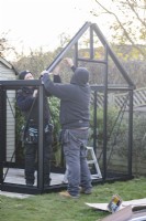 Men assembling greenhouse