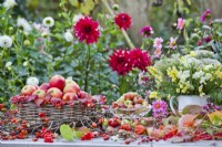 Outdoor table arrangements with harvested apples and bouquet of Antirrhium.