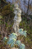 Stone statue in cottage garden in winter