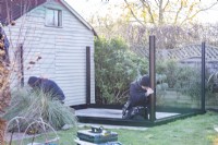 Men placing corner posts on the greenhouse base