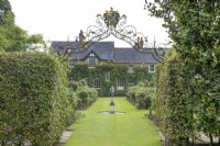 View of the house through the hedges and metalwork at The Burrows Gardens, Derbyshire, in August