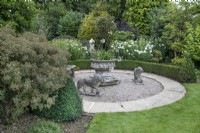 Circular seating area with stone lions at The Burrows Gardens, Derbyshire, in August