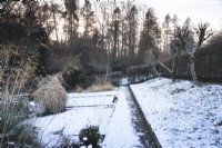 Path through a snowy vegetable garden in December.