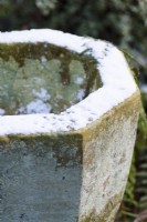 Snow coating the surface of a stone container