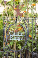 Gate with decorative name plate incorporated into the design in a country garden.