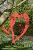 Decorative red hearts mobiles hanging in tree at Keukenhof.