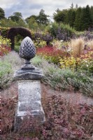 Pine cone finial underplanted with Heuchera villosa 'Palace Purple' at Whitburgh House Walled Garden in September.