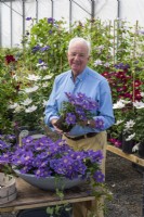Raymond Evison in his nursery, planting up a bowl with Clematis 'Bijou' as a main display