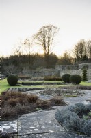The Jewson Terrace at Cotswold Farm Gardens in February with geometric beds and clipped yew.