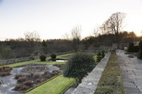 The Jewson Terrace at Cotswold Farm Gardens in February with geometric beds and clipped evergreens including yew and box..