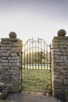 A gate leading out of the garden into the surrounding countryside at Cotswold Farm Gardens in February.