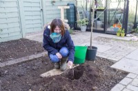 Woman placing compost at the bottom of the hole