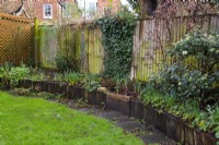 A 'Before' photo of a London garden awaiting a makeover.  Part of the remit was to replace the rotting railroad sleepers and stone path around the raised bed with a brick wall and path.