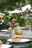 Sandwiches and fermented vegetables in a glass jar on a festively decorated table.