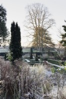 The East Garden at The Bishop's Palace Garden in Wells on a January morning, with evergreen hedges of Euonymus japonicus 'Green Spire'.