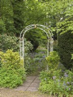 Entrance to woodland garden via  metal arch
