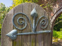 Decorative meatal hinge on garden gate May Spring