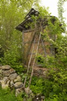 An herb drying tower surrounded by medicinal plants of the Jiri Mountains in A Letter From a Million Years Past, a Show Garden designed by Jihae Hwang at the RHS Chelsea Flower Show 2023