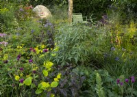 Hebaceous plants including Cirsium 'Trevor's Blue Wonder' and Aquilegia buergiana around a stone cairn  in Horatio's Garden by Charlotte Harris and Hugo Bugg designed to be accessible by those with spinal injuries.