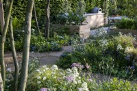 Looking over Aquilegia vulgaris 'Greenapples', Centranthus ruber Albus, Stipa tenuissima and Achillea millefolium to the communal area with vegetables growing in raised beds surrounding a large garden table.London Square Community Garden, Gold winner. Designer: James Smith