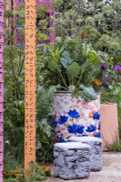 Upcycled oil drums used to grow Kohlrabi, Tagetes patula and herbs. The RHS community garden: Eastern Eye Garden of Unity, Designer: Manoj Malde