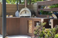 Outdoor kitchen with oven, herb plants and storage - The Chic Garden Getaway - BBC Gardeners' World Live 2023 - Designer: Katerina Kantalis