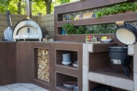 Outdoor kitchen with oven, barbecue, herb plants and storage - The Chic Garden Getaway - BBC Gardeners' World Live 2023 - Designer: Katerina Kantalis