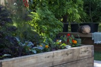 Tomatoes, kale, nasturtiums and marigolds in a raised bed made of wooden sleepers - The Chic Garden Getaway - BBC Gardeners' World Live, Birmingham NEC - Designer Katerina Kantalis