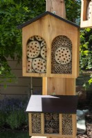 Two wooden garden bug boxes mounted on a post - The Chic Garden Getaway - BBC Gardeners' World Live 2023 - Designer: Katerina Kantalis