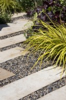 Path made of rectangular slabs set into gravel with plants spilling over - Beautiful Borders - Wow Factor Gardens Paradise in Paperback - BBC Gardeners' World Live 2023 - Designer Eleanor Morgan