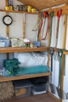 Tools stored neatly in garden shed with nets, containers and seed packets on shelves - Open Gardens Day, Shelfanger, Norfolk