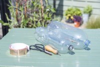 Plastic bottles, bradawl, scissors and copper tape laid out on table