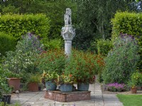 The Scottish Sundial and metal containers with Marigolds Old Vicarage Gardens  East Ruston Norfolk July Summer
