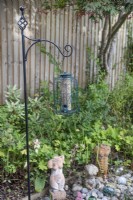 Bird feeding station with seeds in squirrel proof feeder, July