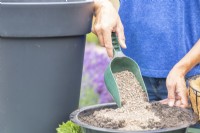 Woman mixing a container of compost and grit