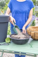 Woman mixing a container of compost and grit