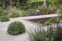 Detail of sandstone terrace and formal pool with incorporated Pittosporum topiary balls for concealing lights and design feature and 