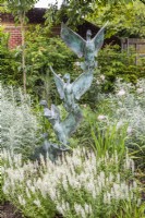 White border with wild duck metal verdigris sculpture .  Plants inc: Salvia sylvestris 'Schneehugel', Rosa 'Desdemona' and 'Queen of Sweden'; Artemisia 'Valerie Finnis' 